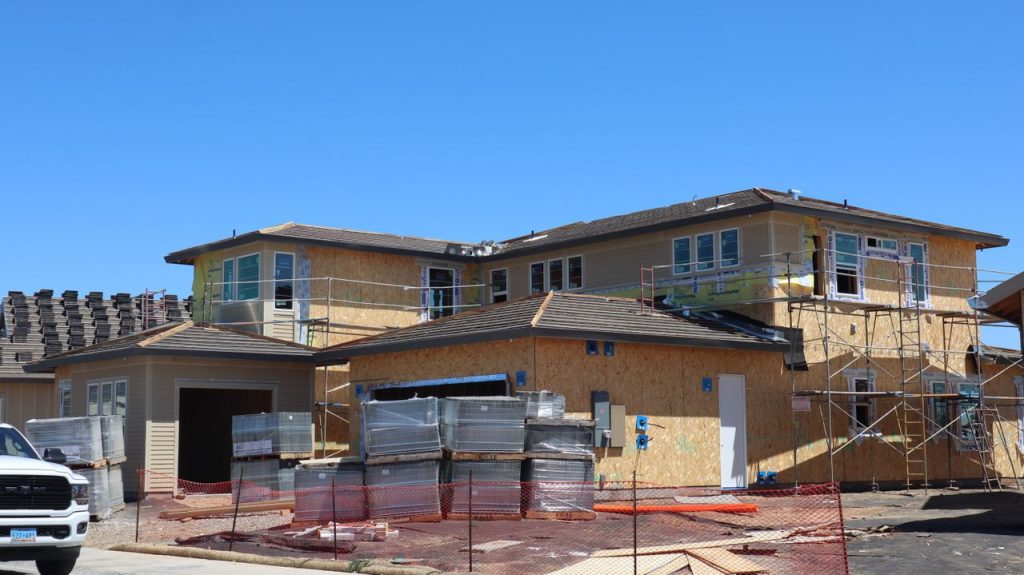 New modern house under construction in Elk Grove, CA, with scaffolding and materials visible.