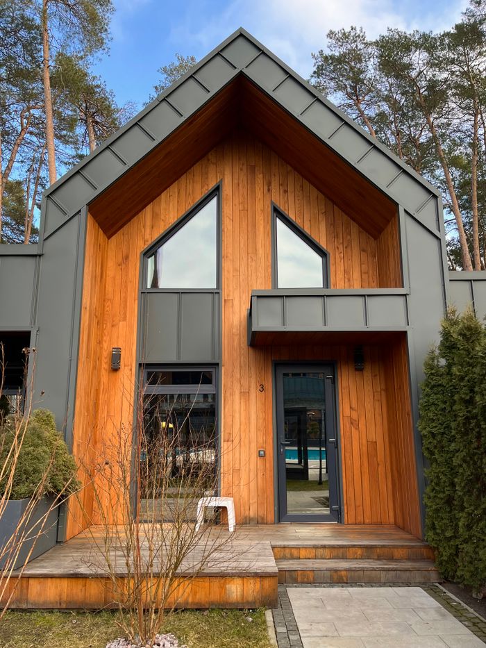 Charming modern wooden house with unique architecture nestled in a serene forest setting.